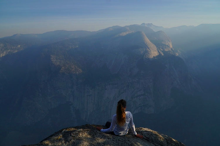 Annasley sitting on top of mountain looking across the landscape